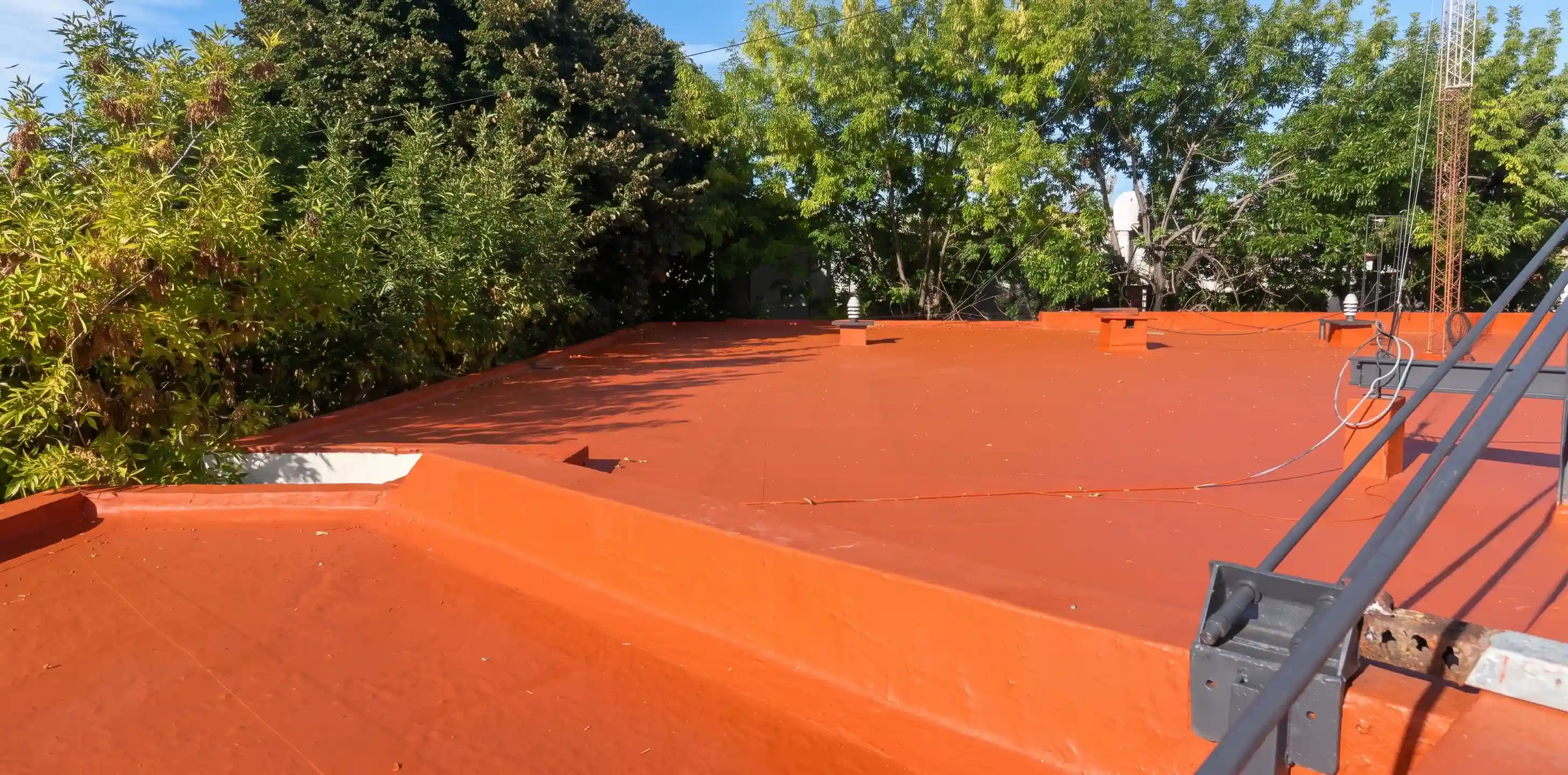 Operario aplicando un tratamiento impermeabilizante sobre una azotea
